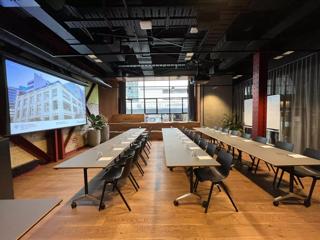 Grey tables are set up in a row, classroom-style in the Dunbar room at Generator on Waring Taylor Street.