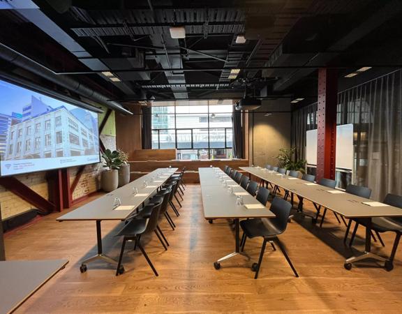 Grey tables are set up in a row, classroom-style in the Dunbar room at Generator on Waring Taylor Street.