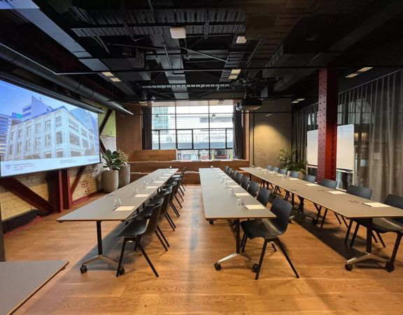 Grey tables are set up in a row, classroom-style in the Dunbar room at Generator on Waring Taylor Street.