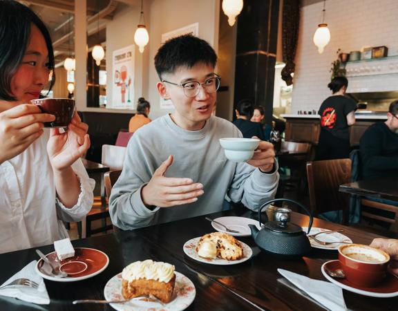 A person chats with friends over coffee and pastries at Floriditas.