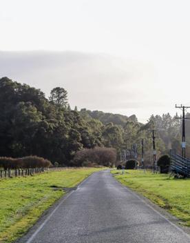 Mangaroa Valley Road screen location, a scenic rural setting with native forest, farmland, and a mountainous backdrop.