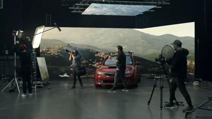 Film crew members filming a car inside of a studio in Wellington.