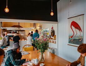 Cosy interior of Tomboy Cafe with people ordering from the counter