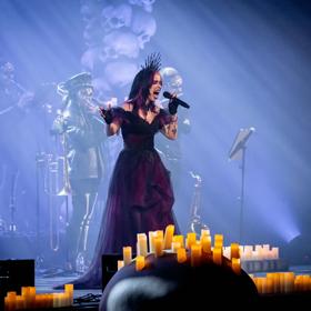 A singer in a dark gown performs in The Rock Orchestra by Candlelight concert.