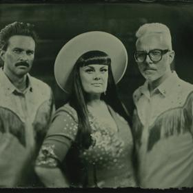 Tami Neilson and two fellow musicians pose for a photo dressed as fashionable cowboys. 