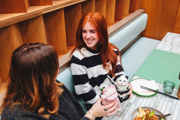 Two friends enjoy a meal and drinks at Mr. Go's, a pan-Asian restaurant in Wellington.