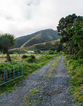 The screen location of Ōrongorongo Station, with many buildings, old and new, as well as views of the ocean and mountains.