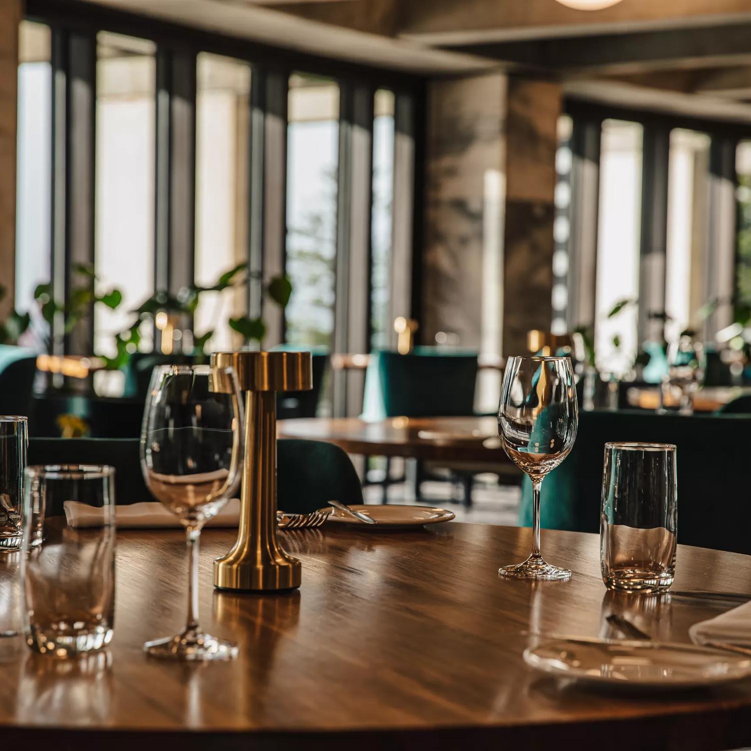 A dining room inside a fancy restaurant with tables set for service.