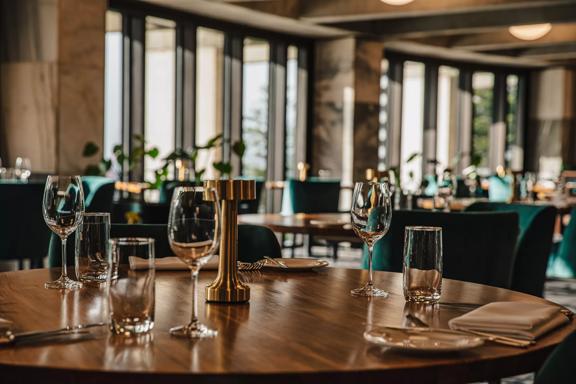 A dining room inside a fancy restaurant with tables set for service.