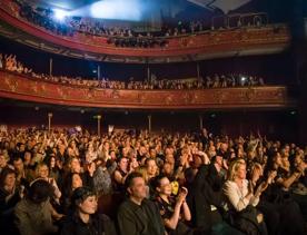 A packed audience cheering and applauding at The Opera House in Te Aro, Wellington.