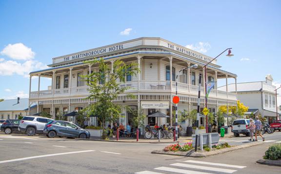 Exterior shot of The Martinborough Hotel, a Victorian era building surrounded by trees and pedestrians.