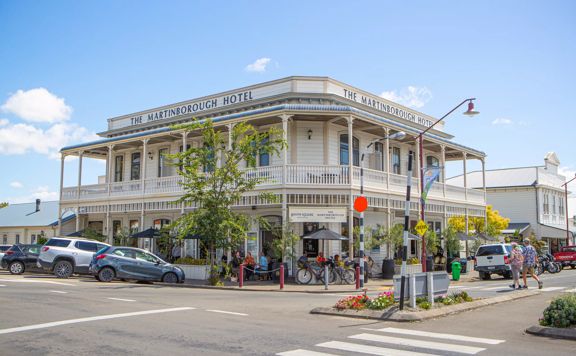 Exterior shot of The Martinborough Hotel, a Victorian era building surrounded by trees and pedestrians.