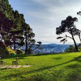 The former Mount Victoria Quarry site sits at the base of Wellington’s Town Belt and has views of the city.  The Anne Frank memorial of three chairs is placed on the grass.