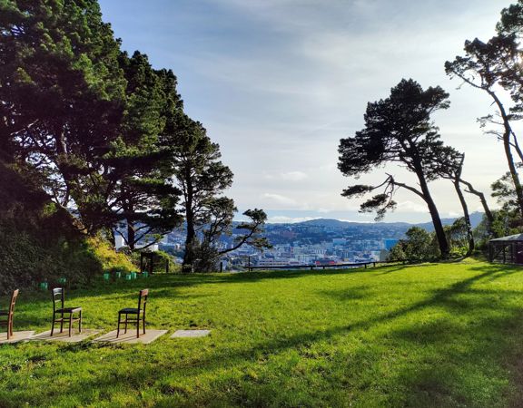 The former Mount Victoria Quarry site sits at the base of Wellington’s Town Belt and has views of the city.  The Anne Frank memorial of three chairs is placed on the grass.