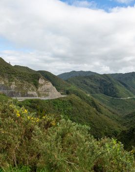 The screen location of Remutaka Summit, wit views of surrounding peaks, lush green bush and steep roads cut into the sides of the mountains.