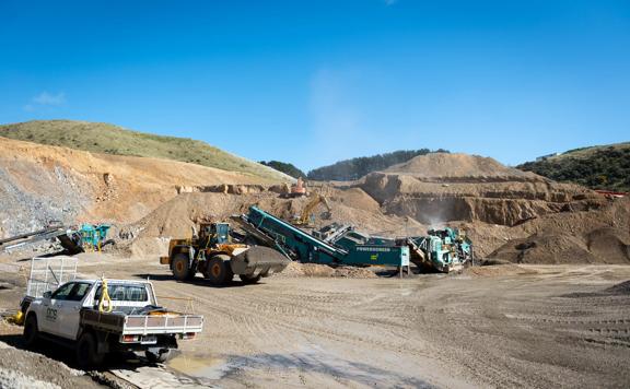 The Willowbank Quarry with a white work truck and other heavy machinery under a sunny blue sky.