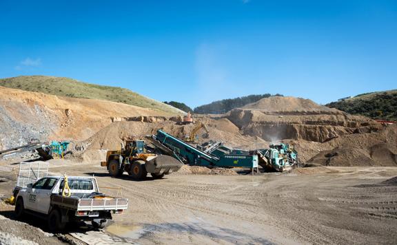 The Willowbank Quarry with a white work truck and other heavy machinery under a sunny blue sky. 