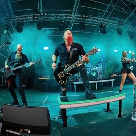 A heavy metal band performs on stage.