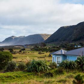 The screen location of Ōrongorongo Station, with many buildings, old and new, as well as views of the ocean and mountains.