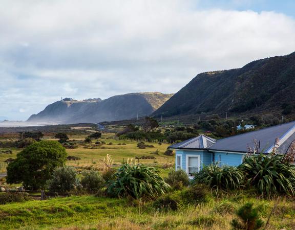 The screen location of Ōrongorongo Station, with many buildings, old and new, as well as views of the ocean and mountains.