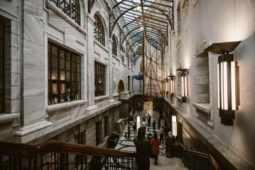 The interior of New Zealand's parliament building in Wellington. It is a large corridor, with stone wall, arched glass ceiling and marble floors.