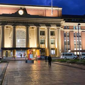 Exterior of Wellington Railway Station, a brick building, at dusk.