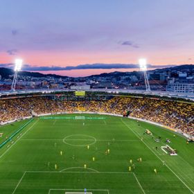 A football match at Wellington Stadium during sunset with a pink blue coloured sky