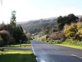 Mangaroa Valley Road screen location, a scenic rural setting with native forest, farmland, and a mountainous backdrop.