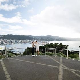 Two people take a selfie together at the Mount Victoria Lookout overlooking Wellington.