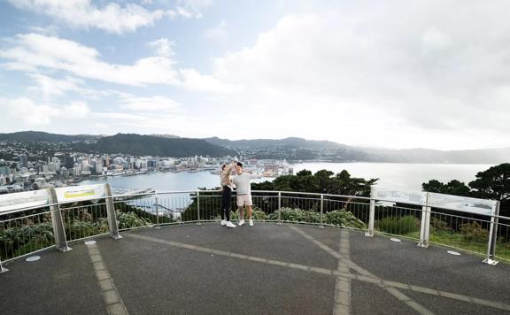 Two people take a selfie together at the Mount Victoria Lookout overlooking Wellington.