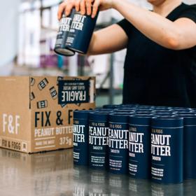 A Fix & Fogg staff member packs peanut butter into a bog in the factory.