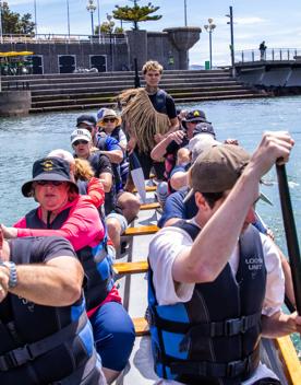 People paddling a Waka Ama, or outrigger canoe in the Whairepo Lagoon.