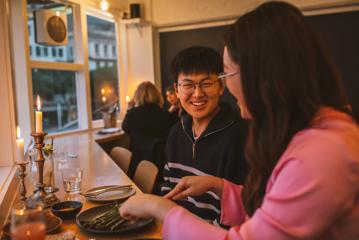 Two people enjoying food and drinks at Supra.