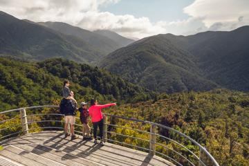 Two adults and two children are at the Rocky Lookout, on Mount Holdsworth in the Tararua Forest Park.