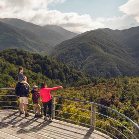 Two adults and two children are at the Rocky Lookout, on Mount Holdsworth in the Tararua Forest Park.