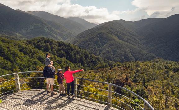 Two adults and two children are at the Rocky Lookout, on Mount Holdsworth in the Tararua Forest Park.