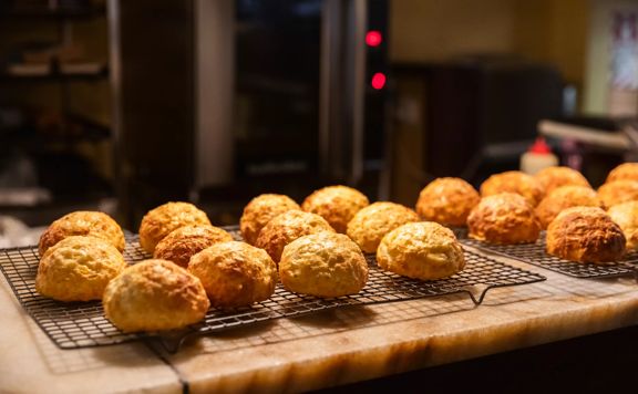 Two cooling racks of freshly baked cheese scones on the counter at Café & Grill, a restaurant in Wellington Central.