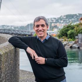 Portrait of David Menéndez Arán leaning against a wall in the wellington harbour.