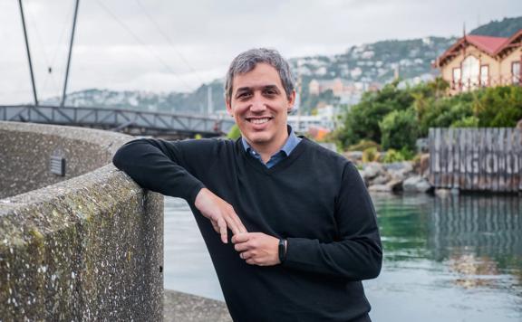 Portrait of David Menéndez Arán leaning against a wall in the wellington harbour.