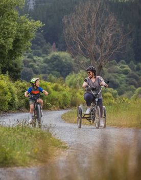 An adult and child cycle along the Hutt River Trail.