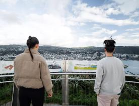 Two people at the Mount Victoria lookout, in Wellington, New Zealand, taking in the views of the city.