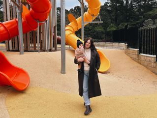 Hannah Carr with her baby at a playground.