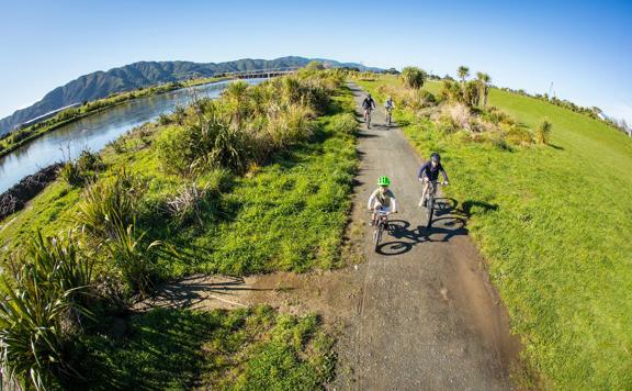 2 adults and 2 children bike alongside the Hutt River.