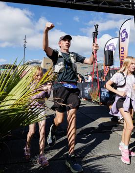 A runner and two kids cross the finish line at Faultline Ultra.