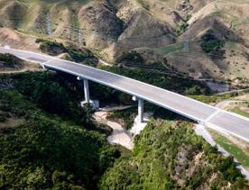 The 4 lane motorway of Transmission Gully, surrounded by green hills.