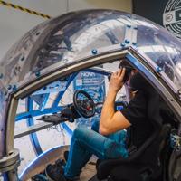 A person sits inside a NOVA, a large plastic sphere with virtual reality capabilities at eight360, a Wellington-based tech company.