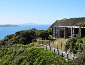 In the foreground is the shooting range and a building made from shipping container, wish bush surrounding. In the background is the view off the Kapati coast with Mana and Kapati Islands.