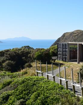 In the foreground is the shooting range and a building made from shipping container, wish bush surrounding. In the background is the view off the Kapati coast with Mana and Kapati Islands.