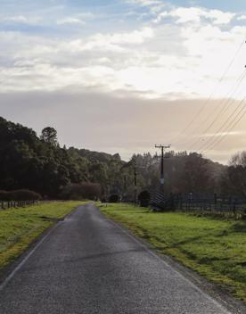 Mangaroa Valley Road screen location, a scenic rural setting with native forest, farmland, and a mountainous backdrop.