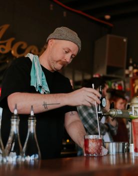 A bartender stirs a cocktail at Ascot.